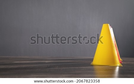 Yellow plastic cone on the table.