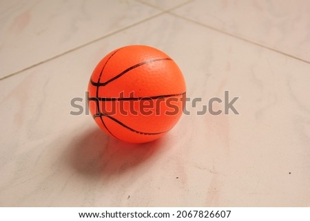 Orange toy basketball on the white floor