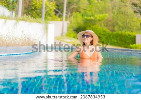 Portrait beautiful young asian woman relax smile leisure around outdoor swimming pool in hotel resort on travel vacation