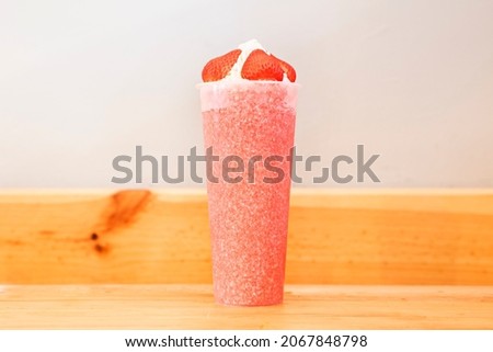 Natural and homemade strawberry smoothie with whipped cream on top. A very healthy shake, full of vitamins and ideal for the whole family
