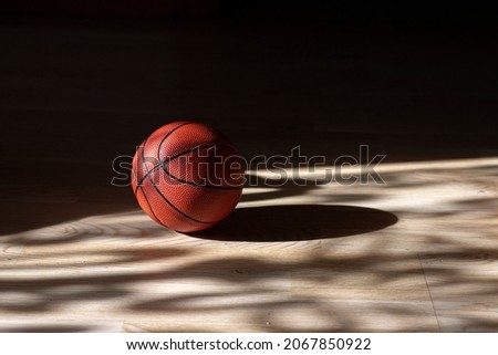 Basketball on hardwood court floor with natural lighting. Workout online concept. Horizontal sport poster, greeting cards, headers, website and app