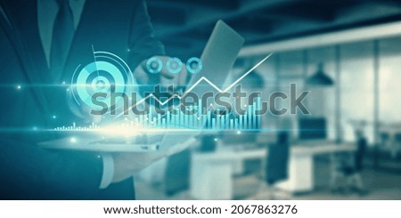 Businessmen using laptop with abstract glowing business chart on blurry city background. Finance, teamwork and innovation concept. Double exposure