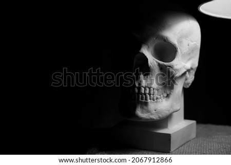 human skull with gypsum as material and as front view picture. isolated on black background. 