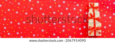 New Year web banner with three gifts, on a red background with gold and silver stars and snowflakes. Christmas card.