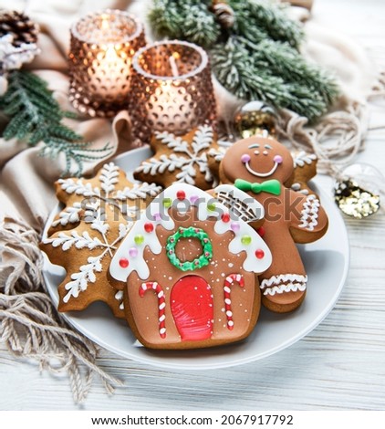Christmas gingerbread in the plate and candles on white wooden background. Top view.
