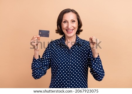 Photo of funky elder ceo brunette lady hold card wear dotted blouse isolated on beige color background