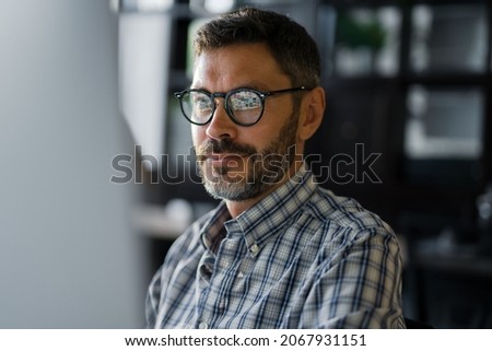 Close Up Young Man in Fashion Glasses Eye Looking Monitor, Surfing Internet. Stylish Male Working With computer From Home in Him Home Office. The Monitor Screen Is Reflected In The Glases
 Royalty-Free Stock Photo #2067931151