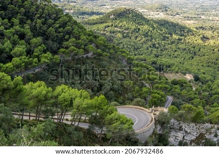 Santuari de Sant Salvador. Access road to the sanctuary. Dangerous curves and otherworldly views. Experiences for drivers and passengers. Climbing to 500 m above sea leve alsofor cyclists. Royalty-Free Stock Photo #2067932486