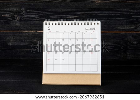 MAY 2022. Calendar and planner on a black wood texture background.
