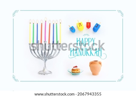 Religion image of jewish holiday Hanukkah with menorah (traditional candelabra), doughnut and candles over white background