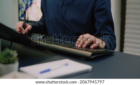 Close up of photographer hands working with graphic tablet and stylus while retouching pictures. Photography artist doing editing work on photos, media editor and retoucher with equipment