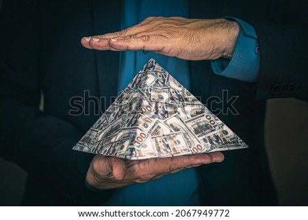a pyramid scheme in the hands of a fraudster. The concept of exchange in financial markets is the collapse of the financial system of capitalism. Royalty-Free Stock Photo #2067949772