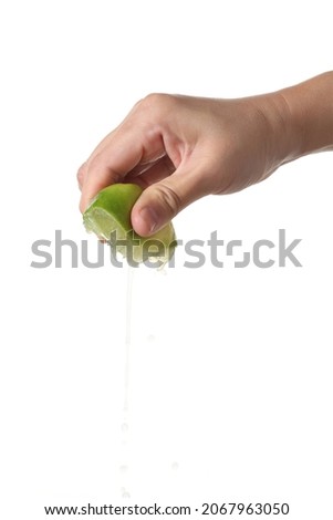 Hand squeeze green lime isolated on white background Royalty-Free Stock Photo #2067963050