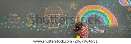 The child draws with chalk on the asphalt. Selective focus. Kid. Royalty-Free Stock Photo #2067964631