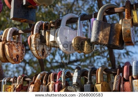 Wedding locks on the fence of the bridge. The concept of the vow of eternal love ceremony, illuminated by the setting sun. Selective focus