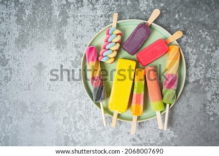 colorful ice cream popsicles on dark backrgound, top view, empty space for your text Royalty-Free Stock Photo #2068007690