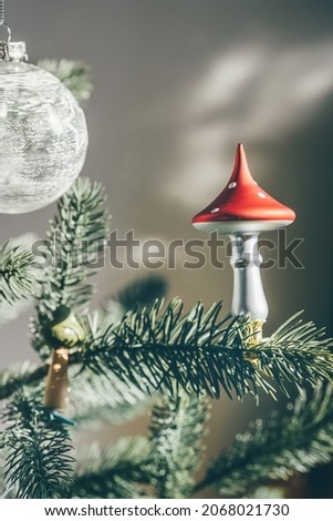 Glass mushroom deco on Christmas tree. Shadows on the wall. Trendy DIY and zero waste concept
