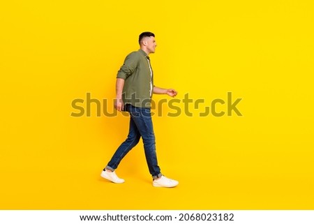 Full length profile side photo of young guy happy positive smile go walk empty space isolated over yellow color background