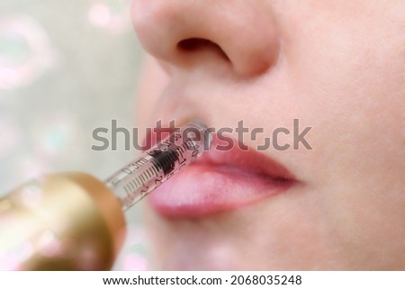 Lip augmentation treatment using needle-free mesotherapy with hyaluron pen device Royalty-Free Stock Photo #2068035248