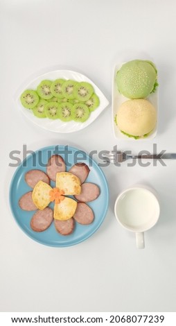 Top view of hamburger, kiwi, ham and milk