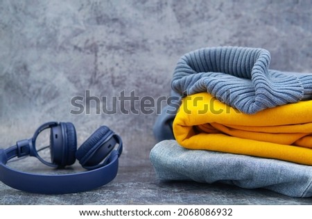 headphones blue sweater gin and yellow hoodie on leans background