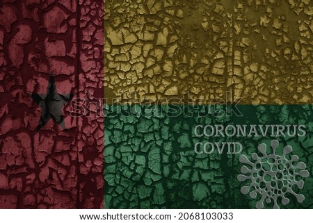 flag of guinea bissau on a old vintage metal rusty cracked wall with text coronavirus, covid, and virus picture.