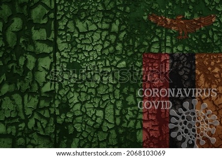 flag of zambia on a old vintage metal rusty cracked wall with text coronavirus, covid, and virus picture.