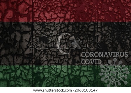 flag of libya on a old vintage metal rusty cracked wall with text coronavirus, covid, and virus picture.