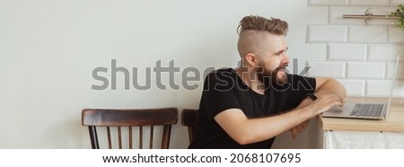Smiling man working with laptop at home. Technology, home and lockdown concept