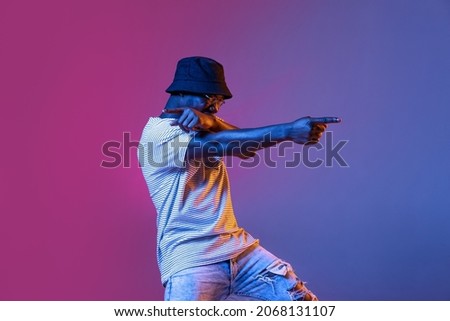 Pointing. Winning success happy man celebrating being a winner. Dynamic image of male model on gradient purple pink studio background in neon. Human facial emotions concept. Trendy colors