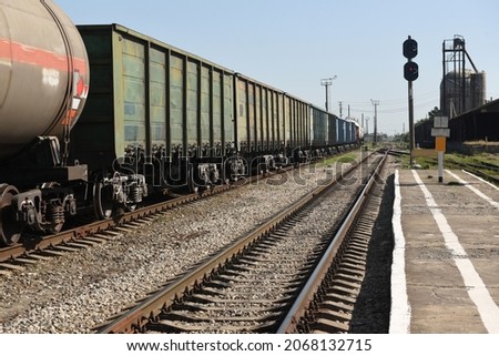 Freight cars and tanks with liquid on the railway on the background of the railway at the station