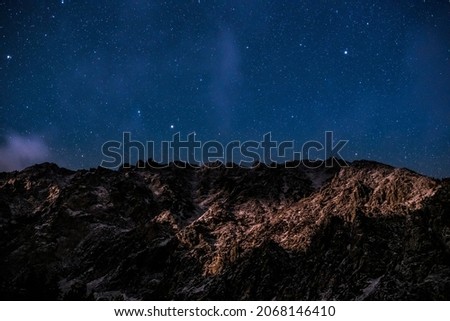 Night sky photo with a clear sky and stars with a snowy mountain in Yosemite national park