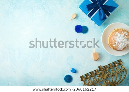 Top view image for jewish holiday Hanukkah with traditional donuts, menorah and gift box