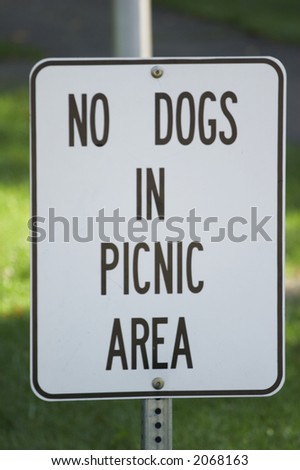 sign: NO DOGS IN PICNIC AREA; seen in the USA