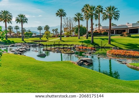 The desert comes alive with Palm Springs green belt landscaping. The arid area is filled with palm trees and flowers surrounding ponds. Royalty-Free Stock Photo #2068175144