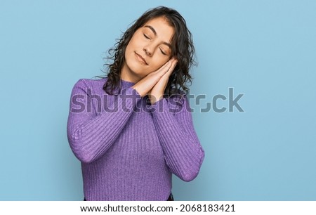 Young hispanic woman wearing casual clothes sleeping tired dreaming and posing with hands together while smiling with closed eyes. 