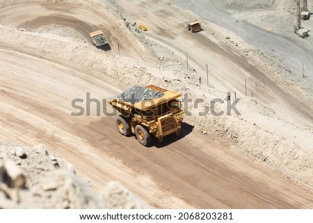 Huge dump trucks loaded with mineral  in a copper mine in Chile. Royalty-Free Stock Photo #2068203281