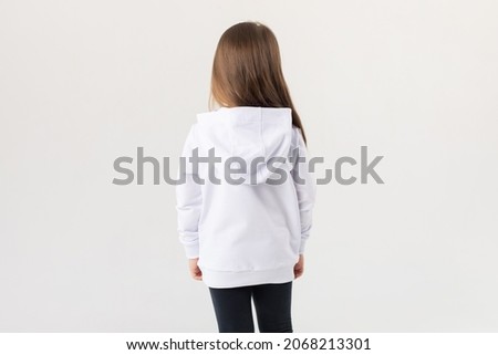 Cute baby girl in a white blank hoodie on a white background. Kids hoodies mockup.