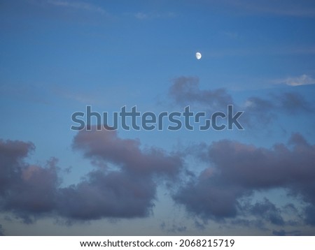 moon shining on a cloudy sky at sunset  