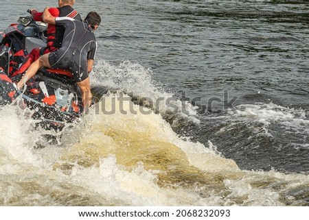 two people are riding on the water at high speed. advertising picture. outdoor recreation. 
an extreme journey on the water. friends on a jet ski.