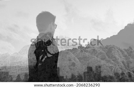 Young man climbing up to top of mountain. Self improvement and motivational goals concept.  Royalty-Free Stock Photo #2068236290