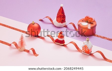 Christmas decorations, a xmas tree and presents are lined up on the red ribbon. Creative minimal concept