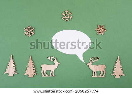 Two cute reindeers talking to each other, speech bubble with copy space, christmas greetings, green colored background