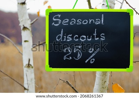 frame with text. seasonal, autumn discounts. Chalkboard and autumn leaves. natural background. the sign with the text weighs on the tree. close-up. sale, big discounts, 25 percent