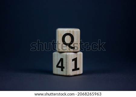 From 4th to 1st quarter symbol. Turned wooden cubes and changed words 'Q4' to 'Q1'. Beautiful grey table, grey background. Business, happy 1st quarter Q1 concept, copy space.