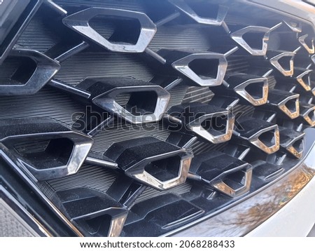 Black texture background: protective car ventilation metal iron grates, dark steel grating with abstract pattern, automobile venting, radiator grid