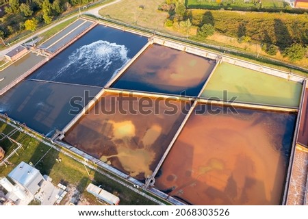A group of large sedimentation tanks. Water settling, cleaning in a reservoir with biological organisms at a water station. different degree of wastewater treatment Royalty-Free Stock Photo #2068303526