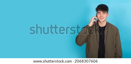 isolated young teenager boy talking on cellphone