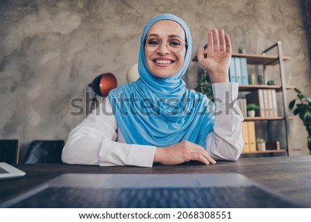 Photo of funky young entrepreneur asian lady greeting online wear glasses scarf shirt indoors workstation