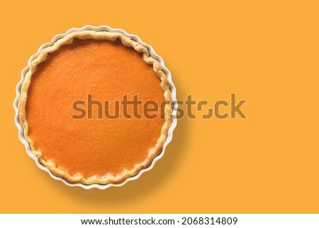 Homemade Traditional American Pumpkin Pie with spices, cinnamon, cardamom, ginger for Thanksgiving Day on orange background. View from above. Copy space.